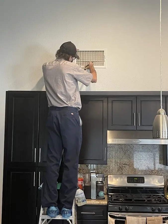 Technician inspecting an air vent during HVAC service in Carolina Shores